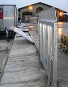 Sliding drawbridge leveler on rail